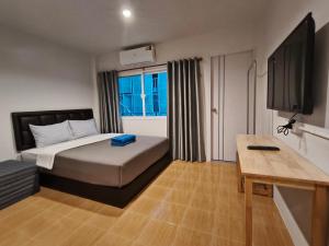 ein Schlafzimmer mit einem Bett, einem Schreibtisch und einem Fernseher in der Unterkunft D45 Home - BTS Ratchathewi N1 Station in Ban Nong Chaeng + 8 Fotos