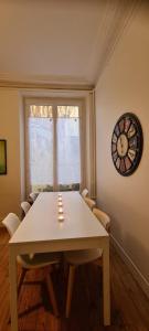 维希L'Absolu 1, Spacieux, rez-de-chaussée, Sécurisé的一间设有桌子和墙上时钟的餐厅