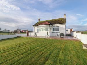 a house with a large lawn in front of it at Marchdyke Farm Cottage in Lockerbie