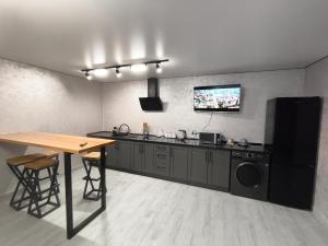 a kitchen with a table and a tv on the wall at Котедж у Русина in Pilipets