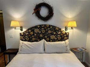 a bedroom with a bed with a flower headboard and two lamps at Sal's Beach Cottage Retreat in Fort Bragg