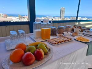 a table with a plate of fruit and other food at Hotel Khantati SPA in Iquique