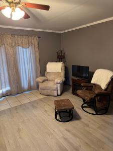 a living room with a couch and a chair and a television at Fireflies and night skies! in French Lick