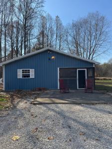 a blue building with two red chairs in front of it at Fireflies and night skies! in French Lick