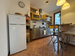 a kitchen with a white refrigerator and a table at Piccola Oasi in Pantigliate +18 photos