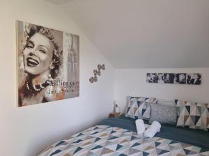 a bedroom with a bed with a poster on the wall at Maison en bois in Lontzen