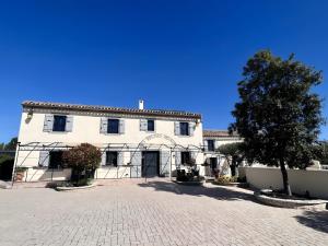 a large white building with a tree in front of it at Gîte Ponpon - Les Petites Écuries in Marseillette