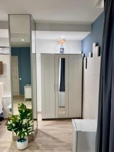 baño con espejo y planta en una habitación en B&B Berlen, en Torre Maggiore