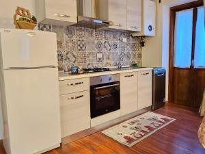 a kitchen with a white refrigerator and a sink at Appartamento Sorapiss in Lorenzago