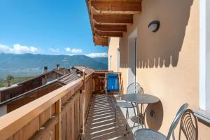 a balcony with a table and chairs on a building at Agriturismo Vento Alpino in Coredo