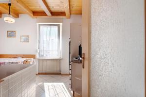 a kitchen with a refrigerator and a window at Agriturismo Vento Alpino in Coredo +104 photos