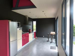 eine Küche mit roten Schränken und einer schwarzen Wand in der Unterkunft Hâvre de Paix Perros in Notre Dame de la Clarté + 14 Fotos