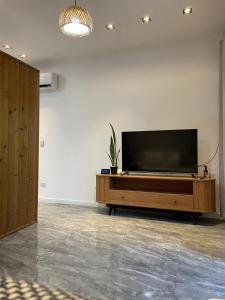 a flat screen tv sitting on top of a wooden entertainment center at Murakami Pousada in Itanhaém