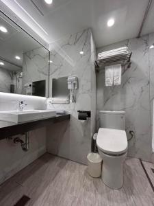 a bathroom with a toilet and a sink and a mirror at Forward Suites Ⅰ in Taipei +48 photos