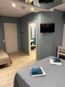 Una habitación con una cama con toallas azules. en B&B Berlen, en Torre Maggiore