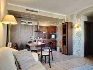 a living room with a table and a kitchen at Apartment in Hotel Royal Beach 5 Pool View in Sunny Beach