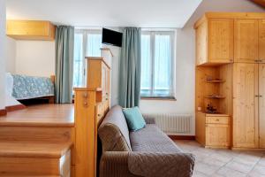 a living room with a couch and a tv at Agriturismo Vento Alpino in Coredo