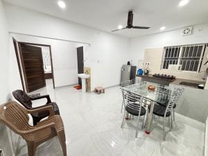 a kitchen with a glass table and chairs at Hoppin Homestay in Guwahati
