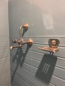 a metal faucet on a tiled wall with a box on it at Bedroom with Balcony and Boudha Stupa View in Kathmandu