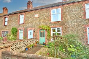 斯内蒂瑟姆Carrstone Cottage, Snettisham的一座带绿门的老砖屋