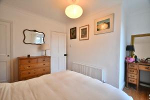 斯内蒂瑟姆Carrstone Cottage, Snettisham的带床、梳妆台和镜子的卧室