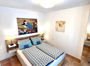 a bedroom with a bed and a painting on the wall at Gîte Tango - Les Petites Écuries in Marseillette