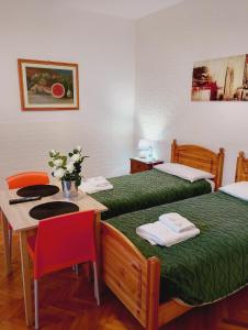 two beds in a room with a table and chairs at B&B RINGAT in Mori