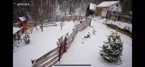 a snow covered yard with a fence and trees at Chata Pavlinka in Chvojnica