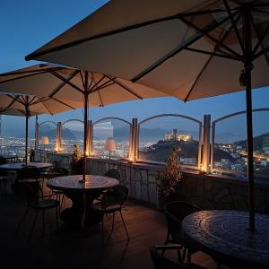 un restaurant avec des tables et des parasols sur un balcon dans l'établissement Pantarei Palace, à Lettere
