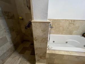 y baño con bañera blanca y ducha. en Condo 1bdr 1bth with garden, en Punta Cana