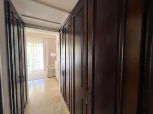 Un pasillo con armarios negros y una habitación con ventana. en Condo 1bdr 1bth with garden, en Punta Cana
