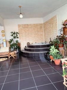 a room with a bath tub with plants in it at Suite Bohème avec Jacuzzi in Sahoué