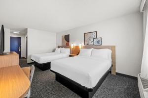a hotel room with two beds and a tv at Spark By Hilton Cleveland Beachwood in Beachwood