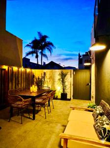 een patio met een tafel en stoelen in de nacht bij Steps to Beach - New Surf Casita - AC & Cozy Fire Pit in Newport Beach