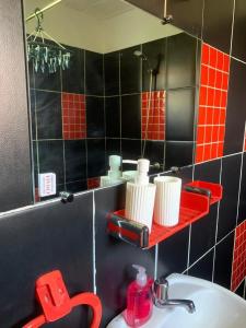 a bathroom with a sink and a mirror at Suite Bohème avec Jacuzzi in Sahoué