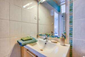 une salle de bain avec un lavabo et un miroir dans l'établissement Chambre d'hôtes - Le quartier haut, à Sète