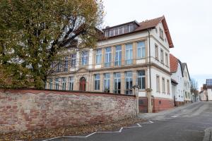 an old brick building on a street with a stone wall at Loft - Zur alten Schule in Essingen in Essingen