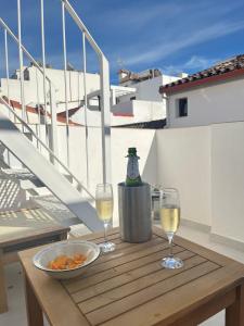 a table with two glasses of wine on a balcony at Fabulous 2 bed-townhouse with large rooftop! in Estepona