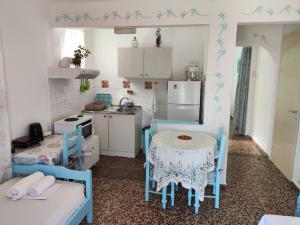 a kitchen with a table and two chairs and a kitchen with a sink at Magdalini in Votsi