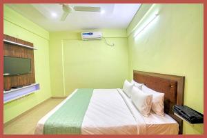 Un dormitorio con una cama y un televisor en una habitación. en Mahakaleshwar Jyotirlinga Temple Hotel A- Palace Near Railway Station - Parking with Room Service, fully air Conditioning Rooms - Best Hotel in Ujjain, en Ujjain