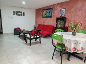 een woonkamer met een tafel en een rode bank bij Plaza de Bolivar in Bogota