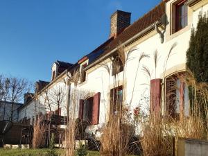 an old white house with tall grass at Éco-domaine Gîtes et Spa - Mer, Nature & Confort - Côte d'Opale in Wierre-Effroy