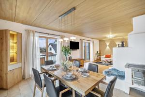 une salle à manger et un salon avec une table et des chaises dans l'établissement Fewo Mit Herz Und Holz Penzing, à Penzing