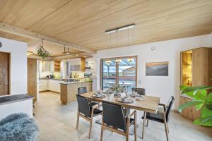 une salle à manger et une cuisine avec une table et des chaises dans l'établissement Fewo Mit Herz Und Holz Penzing, à Penzing