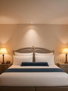 Un dormitorio con una gran cama blanca con dos lámparas. en Precesion Palace Suites Near Delhi Airport, en Nueva Delhi