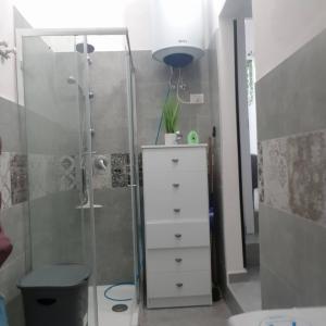 a bathroom with a shower and a white dresser at casa di Francesco e Azzurra in Torre del Greco