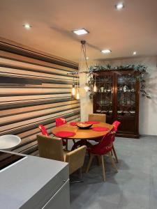 Un comedor con una mesa y sillas rojas. en Casa Grila, en Pontevedra