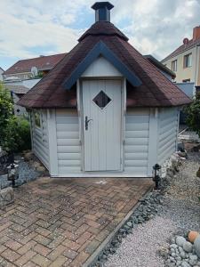 un petit hangar blanc avec un toit mansardé dans l'établissement Haus Maisonette am Harz, à Niedersachswerfen