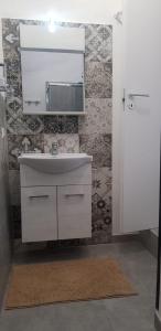 a bathroom with a white sink and a mirror at casa di Francesco e Azzurra in Torre del Greco