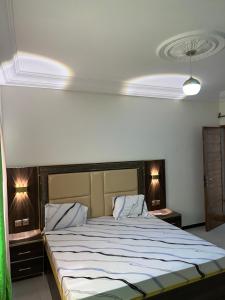 达喀尔2chambres salon au sicap liberté 2的卧室内的一张大床,配有两盏灯